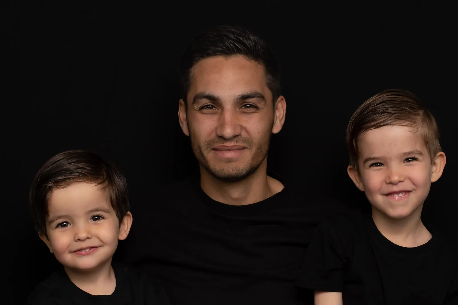 Vader met zijn twee zoons tijdens een gezinsfotoshoot