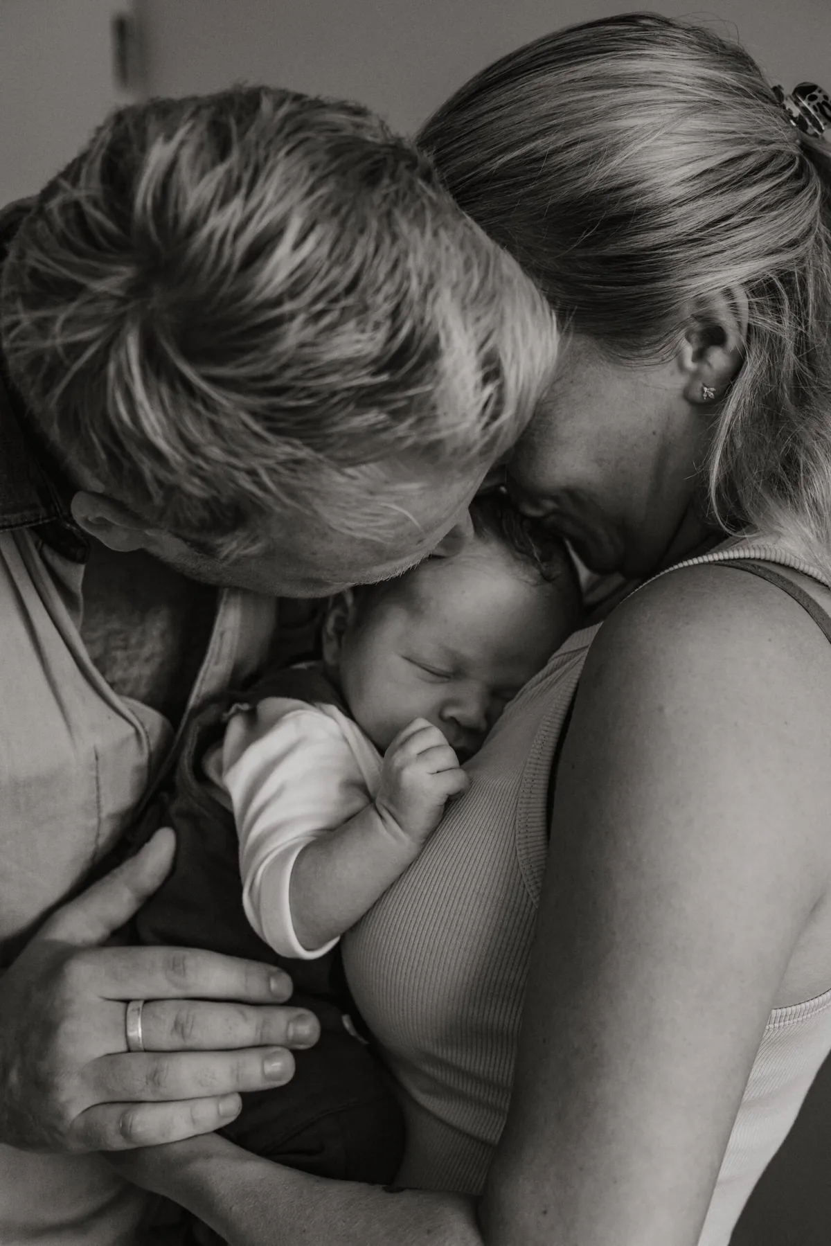 Ouders houden hun newborn baby vast